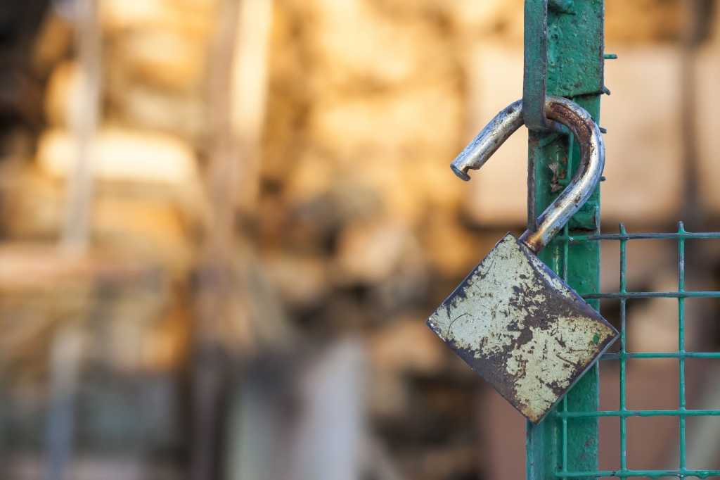 shutterstock 144587243 open padlock hanging on a green gate rusty padlock unlocked padlock