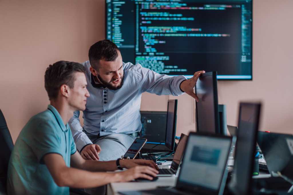 Programmers engrossed in deep collaboration, diligently working together to solve complex problems and develop innovative mobile applications with seamless functionality.